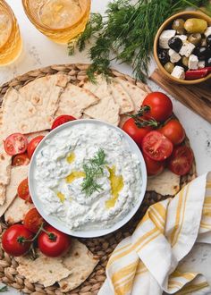 an assortment of food including pita bread, tomatoes and olives