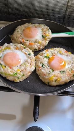 three fried eggs on top of biscuits in a frying pan