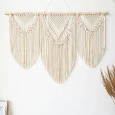 three macrame wall hangings on a white wall