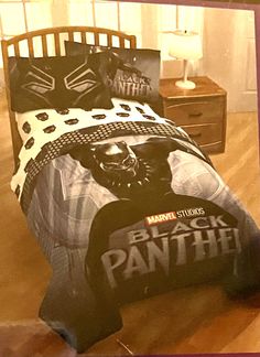 a bed with a black panther comforter and pillows