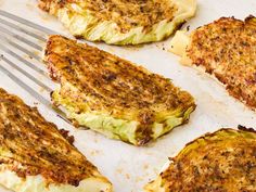 four pieces of grilled food on a baking sheet with a fork in the middle