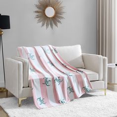 a living room with a white couch and pink blanket