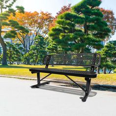 a park bench sitting on the side of a road in front of some pine trees