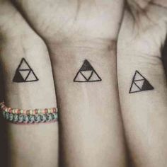 three small tattoos on their wrists with triangle and triangles in the middle one is black