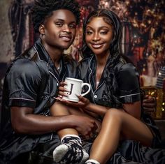 a man and woman sitting next to each other holding a coffee cup