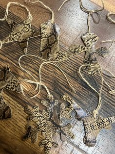 some brown and white ornaments on a wooden table with string attached to them, including one in the shape of a snowflake