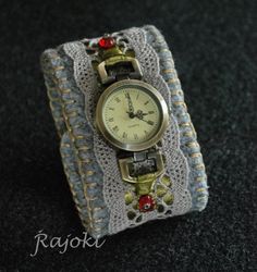 a watch sitting on top of a piece of fabric with beads and chains around it