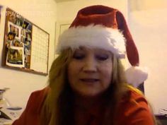 a woman wearing a santa hat while sitting in front of a laptop computer on top of a desk