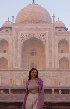 a woman standing in front of the tajwa, india mosque with her hand on her hip