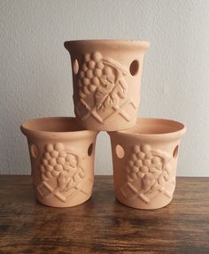 four vases sitting on top of a wooden table next to each other with designs on them