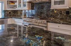 a kitchen with marble counter tops and white cabinets