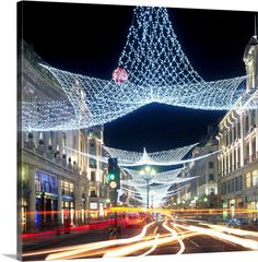 a city street is lit up with christmas lights and garlands in the shape of a star