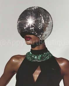 An editorial masterpiece where the model, adorned with a disco ball head and a striking black gown, showcases a green emerald necklace, blending glamour with futuristic fantasy. Disco Chic Party, Disco Black Women, Singer Vision Board, Camp Style Fashion, Black Glamour Aesthetic, Disco Ball Makeup, Retro Disco Outfit, 1970s Party Theme, Futuristic Disco