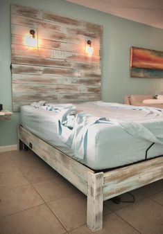 a bed made out of pallet wood in a room with tile flooring and blue walls