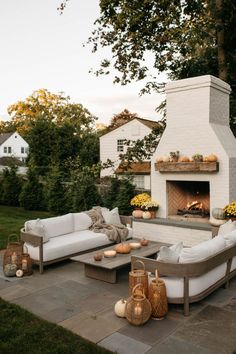 an outdoor fireplace with couches and tables in front of it