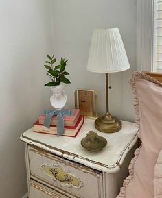 a nightstand with books and a lamp on it