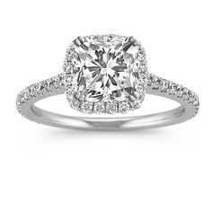 an engagement ring with a cushion cut diamond surrounded by pave diamonds