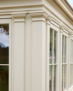 an outside view of a house with white trim and windows