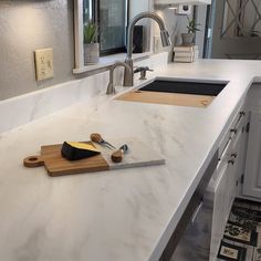 a kitchen counter with two cutting boards and a knife on it next to a sink