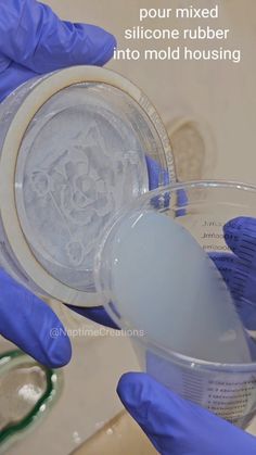 a person in blue gloves pours liquid into a container