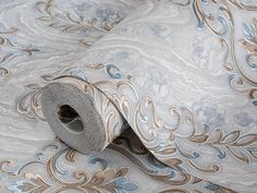 a roll of blue and gold wallpaper with an intricate design on it's surface