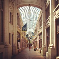 an empty shopping mall with people walking down it