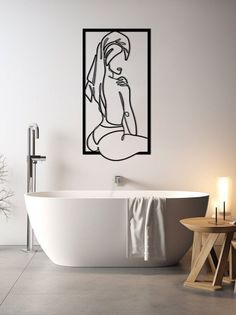 a white bath tub sitting next to a wall with a drawing on it's side