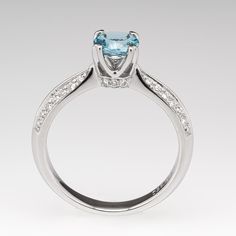 The ring is centered with one (1) round mixed cut natural aquamarine weighing 0.71 carat and set into a four-prong head. The side faces of the ring are each accented with three (3), bead set, round brilliant cut diamonds. The shank features a knife edge profile and is accented with two- rows of seven (7), bead set, round brilliant cut diamonds on each side. The ring measures 6.3mm at the top, rises 7.2mm above the finger, tapering to 2.8mm wide and 1.5mm thick at the base of the shank. We offer Aquamarine Engagement Ring, Bead Set, Natural Aquamarine, June Birth Stone, Brilliant Diamond, Round Brilliant Cut Diamond, High Quality Jewelry, Brilliant Cut Diamond, Estate Jewelry