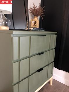 a green dresser with drawers on top of it and a vase sitting on top of it