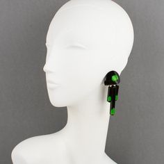 This is part of Chairish’s Costume Jewelry assortment.  Stunning modernist Lucite dangling clip-on earrings. Carved dimensional geometric shape with black Lucite background topped with green gumdrops inclusions embedded in yellow apple juice Lucite. No visible maker's mark. Measurements: 3.19 in high (8 cm) x 1.38 in.wide (3.4 cm).  Please see the measurements noted above in the description for the best approximate dimensions. Yellow Apple, Makers Mark, Costume Jewelry, Geometric Shapes, Clip On Earrings, Carving, Green, Black