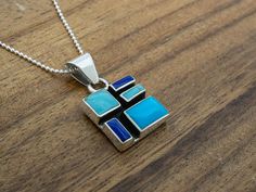 We love all the colors our artists put in our Mosaic Collection. Delivered on an 18” Faceted Bolita Chain. Weight: 8.5 grams Unique Blue Necklace With Polished Finish, Unique Blue Necklace With Inlay, Blue Necklace With Round Inlay, Artisan Blue Inlay Necklaces, Artisan Blue Necklace Stamped 925, Blue Sterling Silver Necklace With Inlay, Blue Pendant Jewelry With Box Chain, Blue Pendant Necklace With Box Chain, Blue Box Chain Necklace As A Gift