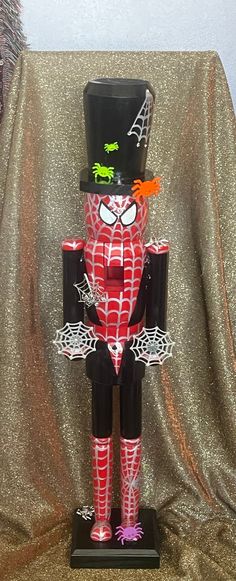 a wooden nutcracker with a top hat and spider legs