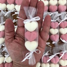 a hand is holding several heart shaped candies