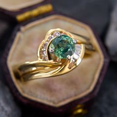 a close up of a ring with a green stone in it