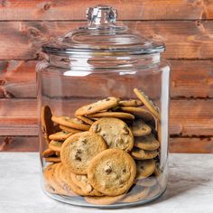 a glass jar filled with cookies on top of a table