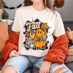 "Comfort Colors®, Retro Fall T-Shirt, Fall Lovers Tee, Vintage Autumn Leaves Shirt, Fall Vibes Tee, Smiley Face Fall,Boho Fall Shirt, Pumpkin *ABOUT OUR TEES QUALITY -Printed by our professional printing machine.  * Comfort Colors 1717 Unisex Heavyweight Tee Features -6.1 oz./yd² (US), 10 oz/L yd (CA), 100% ring spun cotton, 20 singles -Garment-dyed soft ring spun fabric -Relaxed fit -Topstitched, classic width, rib collar -Twill taped neck and shoulders -Twill label *HOW TO  ORDER 1-Browse all pictures. 2- Mark your \"Size\" and \"Color\" selections from the drop-down menus. 3- choose your quantity. 4-You can continue your payment process by clicking the \"Add to Cart\" button. **If you want to add more t-shirts; go back and repeat the same steps. *PRODUCTION- SHIPPING Our Production Time White Graphic Print T-shirt For Fall, Fall White T-shirt With Screen Print, Fun White T-shirt For Fall, White T-shirt With Screen Print For Fall, White T-shirt With Funny Print For Fall, Fall Lovers, Vintage Autumn, Boho Fall, Printing Machine