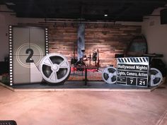 a movie set with film reels and clapsticks in front of a brick wall