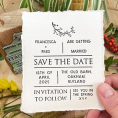 a person holding up a paper save the date card