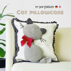 a crocheted cat pillow sitting on top of a white couch