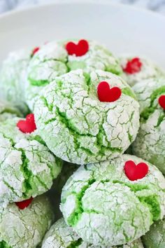 green christmas cookies with red hearts in the middle and text overlay that reads, the grinn christmas cookies