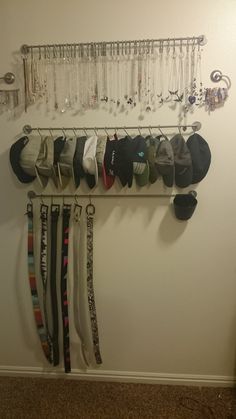 a rack with hats and ties hanging from it's sides next to a wall