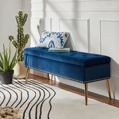 a blue bench sitting on top of a wooden floor next to a potted plant