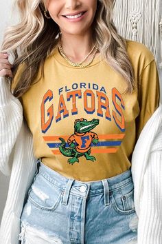 FLORIDA GATORS,FOOTBALL UNISEX SHORT SLEEVE,GRAPHIC TEE,GRAPHIC TSHIRTS,TSHIRTS,TEES100%COTTON,HEATHER(52%COTTON,48%POLY),ATH.HEATHER,BLACK HEATHER(90%COTTON,573%POLY)NICARAGUAMade In: Nicaragua Casual Yellow T-shirt With Team Name, Casual Team-colored T-shirt For Fall, Green Casual T-shirt For Game Day, Casual Tops With Letter Print For Fan Gear, Casual Yellow Tops For Game Day, Casual Green Tops For Game Day, Florida Gators Football, Concealed Carry Handbags, Gators Football