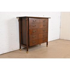 an old wooden chest of drawers with brass handles and knobs on the bottom, against a white brick wall