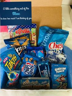 a box filled with lots of snacks on top of a bed