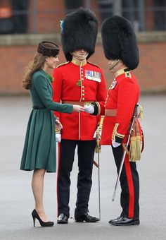 the duke and princess are shaking hands with each other in uniform at an outdoor event