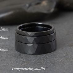 two black rings sitting next to each other on top of a cement floor with measurements