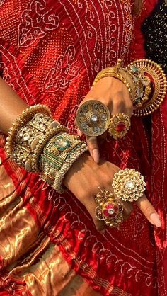 the woman is wearing many different bracelets and rings