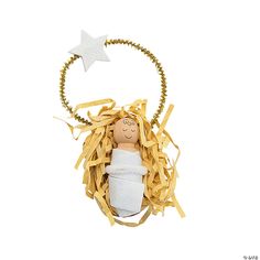 a wooden doll in a basket filled with shredded paper and a star hanging from it's side