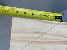 a measuring tape is on top of a piece of wood